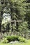 Old wooden cross with crucifix near fence