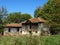 Old wooden decrepit shabby house in need of repair with damaged roof, walls, doors,  and broken windows. Sepis colour.