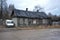 Old wooden dilapidated house and an old car on the street in Borovichi