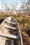 Old wooden dinghy rowboat beached on grass