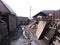 old wooden dirty house in a Siberian untidy village with garbage and scattered things in an unkempt yard behind a broken