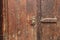 Old wooden door dark red color and old iron lock fragment