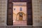 An old wooden door in the entrance of a medieval abbey  with a brick well in the courtyard Gubbio, Italy