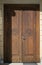 Old wooden door at the entrance to a catholic church. There are different religious symbols on the door