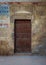 Old wooden door framed by bricks stone wall, Old Cairo, Egypt