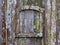 Old wooden door with lichen and moss and a small frame - horizontal background texture