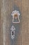 Old wooden door with metal key hole and knocker