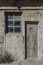 old wooden door with porthole window and a window of a warehouse or barn, wood texture or background, textura de madera o fondo, l