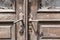 Old wooden door of a shabby demaged house facade. A small town in the mountains of Slovenia, Europe.