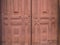 Old wooden door to the monastery in maroon color