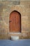 Old wooden door and window framed by arched bricks stone wall at the courtyard of al Razzaz historic house, Old Cairo, Egypt