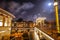 Old wooden Dutch bridge at night time against rush clouds.