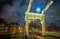 Old wooden Dutch bridge at night time against rush clouds.