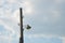 Old wooden electric lamppost against sky.