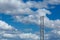 Old wooden electric post against blue sky and clouds