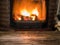 Old wooden empty table and  blurred burning fire in fireplace at the background. Empty tabletop can be used as mock up for photo