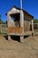 Old wooden feed bunk  with a roof in a horse corral