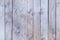 Old wooden fence with faded light gray wood. Smooth vertical boards. Blank background.