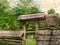 Old wooden fence of a rural dwelling. The fence and entrance are covered with wooden planks. Ancient Rustic lifestyle.  Digital