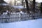 Old wooden fence, snowy suburban area and sun glare