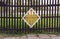 Old wooden fence with a yellow rhombus in the center