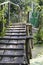 An old wooden footbridge built on the canal, household on a background