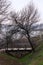 An old wooden footbridge over a ravine in the autumn foggy forest. Empty park near the river. Street travel wallpaper