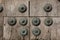 Old wooden gate fixed with large brass rivets