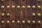 Old wooden gate fixed with large brass rivets in Cordoba, Spain