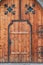 Old wooden gate in front of a house, with spectacular black iron details