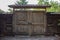 Old wooden gate with ornaments and a small roof with wickets on either side of them