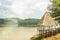 Old wooden gazebo with thatched roof on a river in the nature near the temple of truth