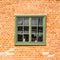 Old wooden green window in a seamless medieval brick wall