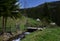 Old wooden house in the forest near the river and forest against the blue sky