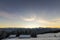 Old wooden house, hut and barn in deep snow on mountain valley, spruce forest, woody hills on clear blue sky at sunrise copy space