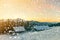 Old wooden house, hut and barn, pile of firewood in deep snow on mountain valley, spruce forest, woody hills on clear blue