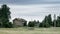 Old wooden house in the meadow. Stone foundation. Rural landscape