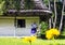 Old wooden house with old woman in flowered ethnic dress