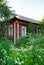 An old wooden house overgrown with trees and grass. Wooden hut. The house is made of logs. An old building. Patterned