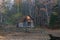 An old wooden house stands alone and neglected in a remote autumn forest.