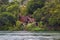 Old wooden house in a traditional Indonesian style with a fishing boat stands in a tropical forest