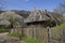 Old wooden houses with straw roof in the village. Carpathians