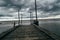 Old wooden jetty, pier, during storm on the sea.  sea horizon under huge dark storm sky and clouds