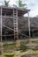 Old wooden ladder near rocks in low tide. Narrow ladder with steps to the sky. Climbing concept. Stairway in tropical resort.