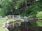 Old wooden lock gates with trees and flowers reflected in the water with mooring posts and fences on the rochdale canal at rawden