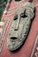 Old wooden mask on red banner. Spirit face of totem. Asian handmade sculpture. Ritual object. Religious art.