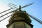 An old wooden mill in summer day on background of village.