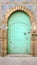 Old wooden Moroccan door with a faded blue green color, Essaouira, Morocco