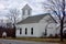 Old wooden New England church in winter with bell tower