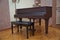 Old wooden piano keys on wooden musical instrument in front view . Big brown wooden piano close up in room